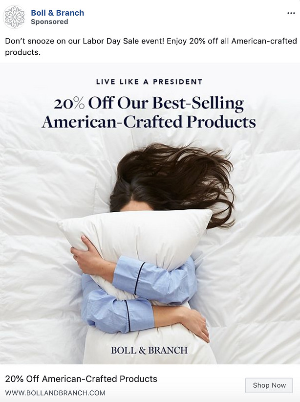A person in blue pajamas hugs a white pillow while lying on a bed. Text promotes 20% off best-selling American-crafted products from Boll & Branch for a Labor Day sale.