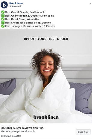 A woman sits on a bed wrapped in a white comforter, smiling. Text above highlights Brooklinen’s accolades and offers 10% off a first order.