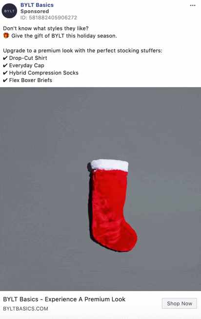 A single red and white Christmas stocking hangs centered on a plain gray background.