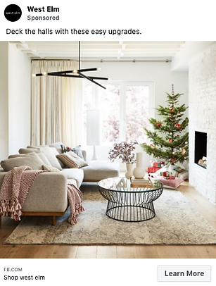 A modern living room with a beige sofa, round coffee table, and Christmas tree by the fireplace, decorated for the holidays.