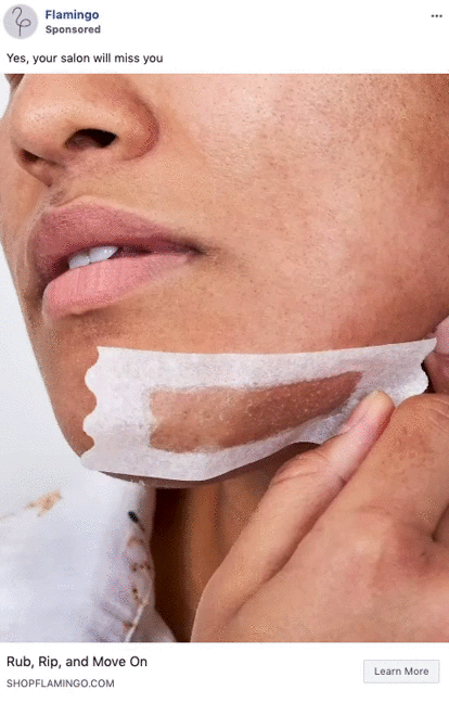 A person is removing a wax strip from their chin, showing part of their lower face and hand during at-home hair removal.