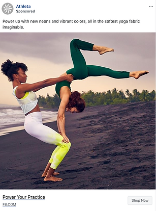 Two women practice acro yoga on a black sand beach, wearing colorful athletic clothing. One supports the other upside down. Palm trees and cloudy sky are in the background.