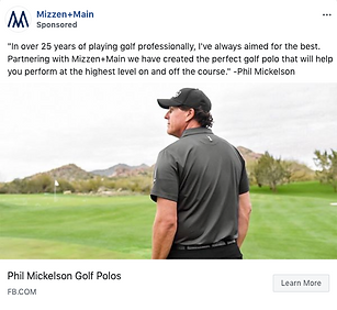 Phil Mickelson stands on a golf course wearing a black Mizzen+Main polo, looking into the distance with golf clubs in hand.