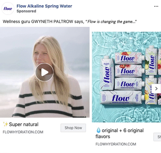 Gwyneth Paltrow stands outdoors in a striped sweater next to a display of Flow Alkaline Spring Water cartons in various flavors.