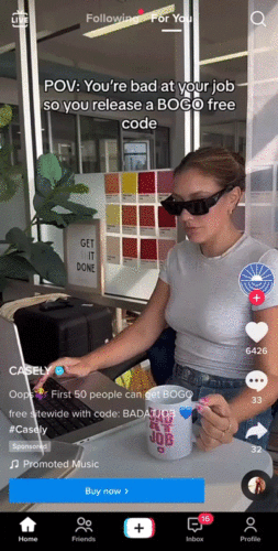 A woman wearing sunglasses types on a laptop at a desk, holding a mug, with text overlay about releasing a BOGO free code for phone cases.