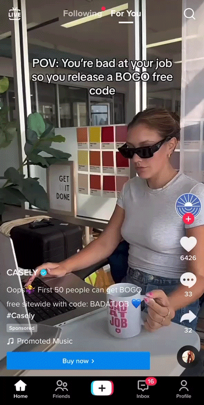 A woman wearing sunglasses types on a laptop at a desk, holding a mug, with text overlay about releasing a BOGO free code for phone cases.