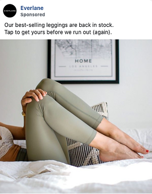 A person wearing light green leggings reclines on a bed with a framed "Home Los Angeles" map artwork on the wall in the background.
