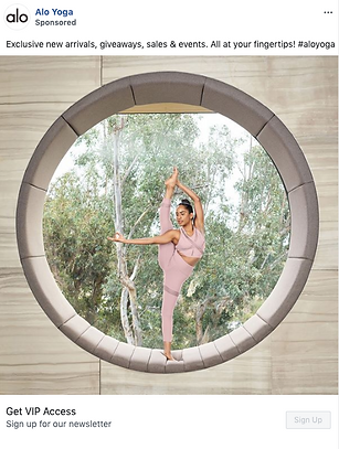 A woman in pink athletic wear performs a standing split pose inside a large circular stone window with trees visible in the background.