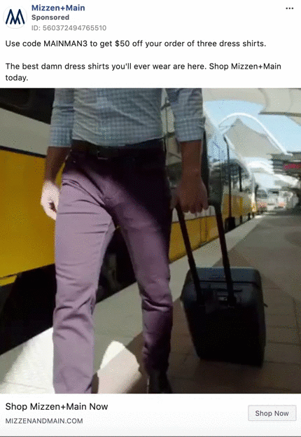 A man in business attire walks on a train platform while pulling a suitcase, with a yellow train in the background.