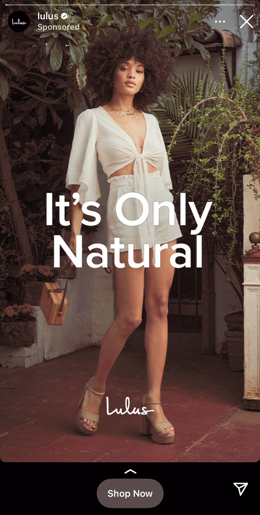 A woman in a white outfit and platform sandals stands in a garden setting with the text "It's Only Natural" overlaid.