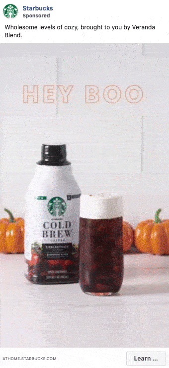 Starbucks Cold Brew bottle and a glass of cold brew are placed in front of mini pumpkins with the words "HEY BOO" in the background.