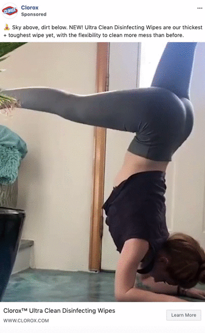 A woman does a handstand with her feet against a wall while cleaning a table with a wipe in one hand. Clorox disinfecting wipes branding is visible.