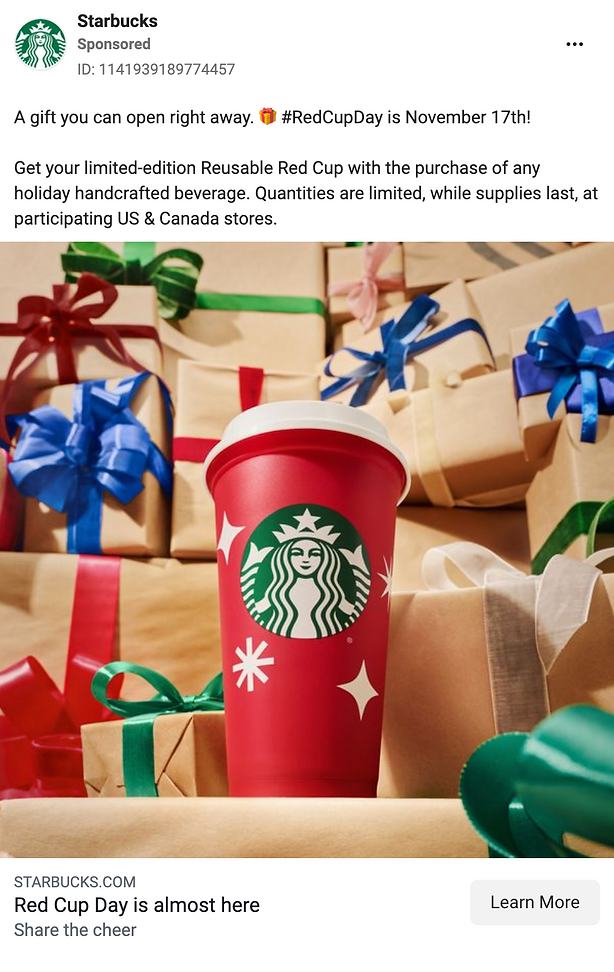 A red Starbucks reusable cup is surrounded by wrapped holiday gifts in various colors, promoting Red Cup Day and the limited-edition cup offer.