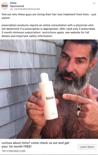 A bearded man with wet hair stands in a shower, holding and pointing to a bottle labeled "hims," promoting a hair loss treatment product.