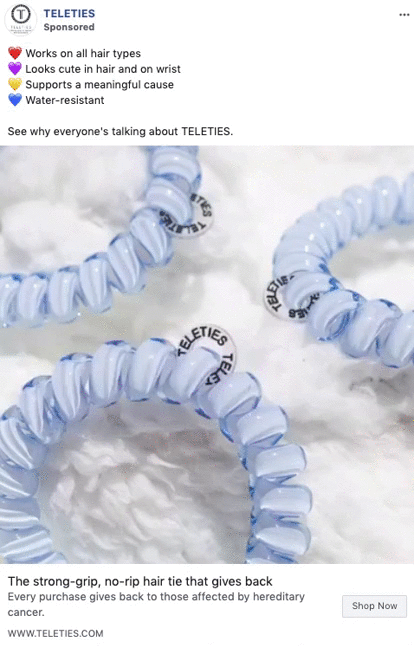 Four light blue, coiled hair ties labeled "TELETIES" are arranged on a fluffy white surface.
