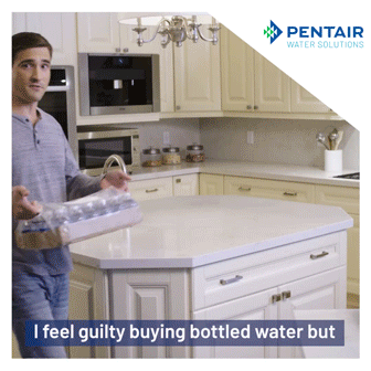 A man places a pack of bottled water on a kitchen counter, with the text, "I feel guilty buying bottled water but," and the Pentair Water Solutions logo in the corner.