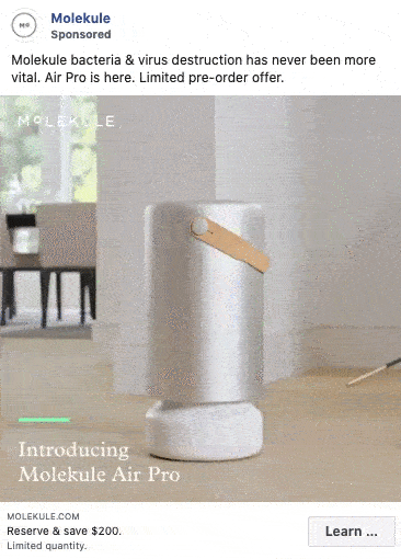 A cylindrical Molekule Air Pro air purifier sits on a stand in a modern room with natural light, featuring a tan leather handle.