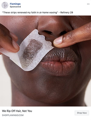 A close-up of a person using a waxing strip on their upper lip, with fingers holding the strip in place.