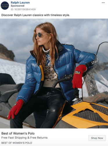 A woman wearing a blue puffer jacket, patterned sweater, red gloves, and sunglasses sits on a yellow snowmobile against a snowy background.