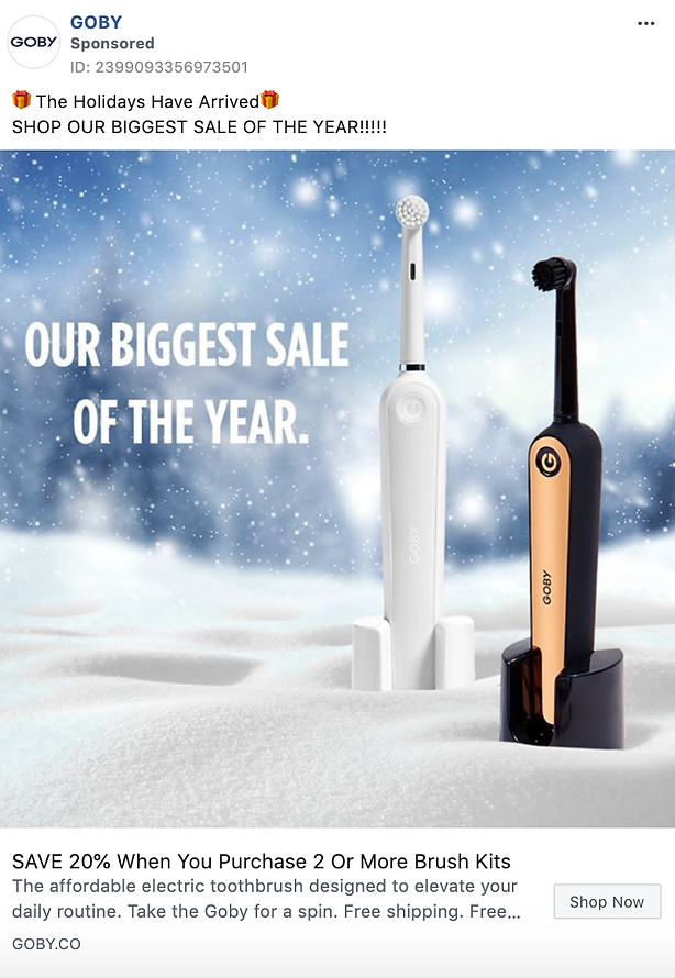 Two electric toothbrushes, one white and one black with gold trim, stand upright in artificial snow with the text: “OUR BIGGEST SALE OF THE YEAR.”.