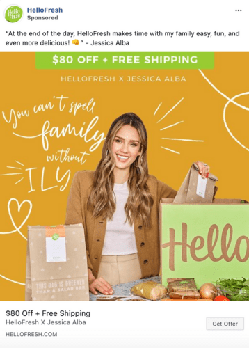 Jessica Alba stands behind a table with HelloFresh meal kits and grocery bags, promoting an $80 off and free shipping offer for HelloFresh in a sponsored ad.