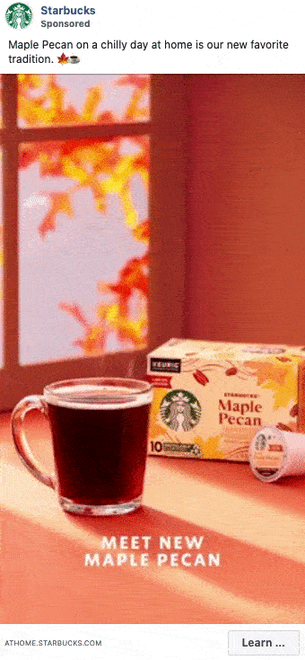 A glass mug of dark coffee sits on a table next to a Starbucks Maple Pecan coffee pod box, with autumn leaves in the background and text reading "Meet New Maple Pecan.