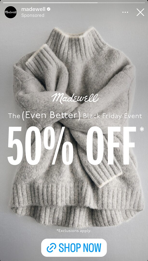 Folded gray knit sweater with white text advertising "Madewell The (Even Better) Black Friday Event 50% OFF*," plus a note about exclusions and a blue "Shop Now" button.