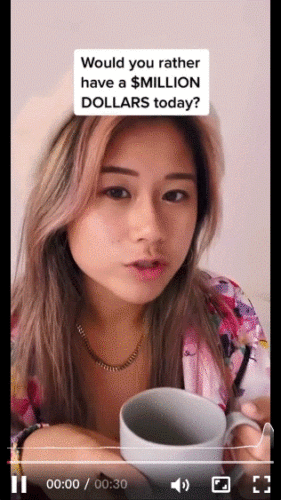 A woman holding a gray mug looks at the camera. Text on the image reads, "Would you rather have a $MILLION DOLLARS today?" Video playback controls are visible at the bottom.