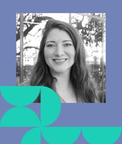 A woman with long hair smiles at the camera; the photo is in black and white with blue and teal geometric shapes framing the image.